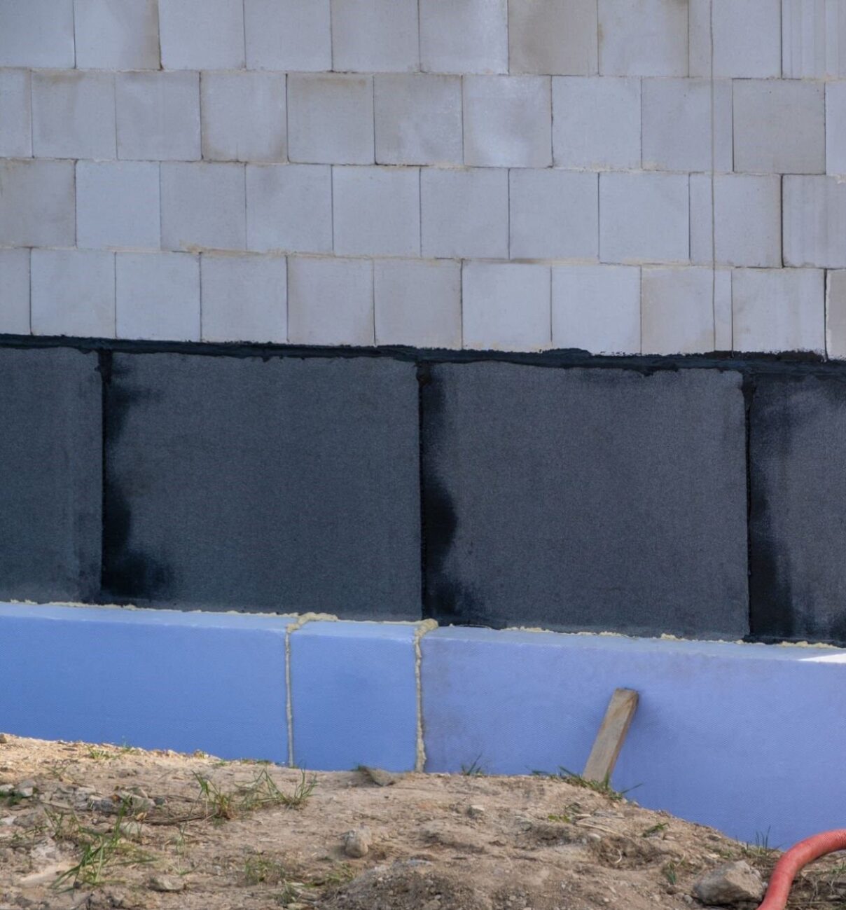 waterproof thermal insulation coatings on the Foundation of the bottom wall in a new private house under construction.   Extruded Polystyrene foam, membrane and bitumen